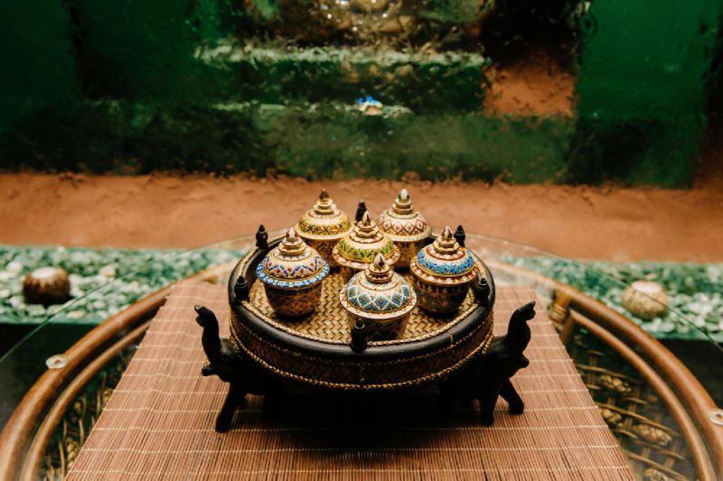 A beautifully arranged set of Benjarong bowls, each adorned with intricate traditional Thai designs and vibrant hand-painted details.