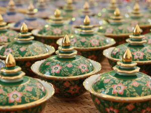 A collection of handcrafted Benjarong ceramics, showcasing intricate patterns and gold embellishments, a traditional Thai porcelain art once reserved for royalty.