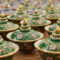A collection of handcrafted Benjarong ceramics, showcasing intricate patterns and gold embellishments, a traditional Thai porcelain art once reserved for royalty.