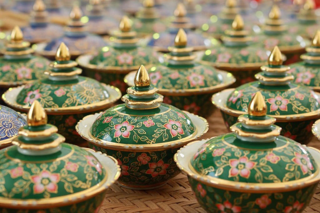 A collection of handcrafted Benjarong ceramics, showcasing intricate patterns and gold embellishments, a traditional Thai porcelain art once reserved for royalty.