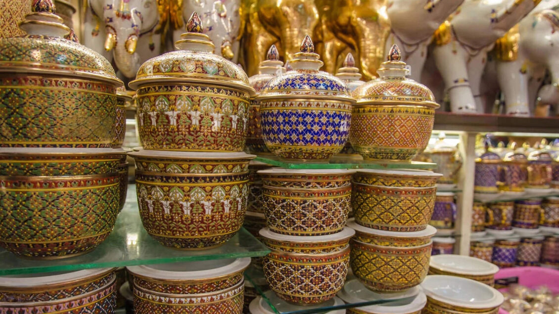 A collection of handcrafted Benjarong ceramics, showcasing intricate patterns and gold embellishments, a traditional Thai porcelain art once reserved for royalty.