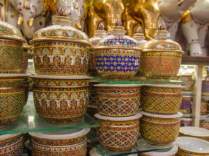 A collection of handcrafted Benjarong ceramics, showcasing intricate patterns and gold embellishments, a traditional Thai porcelain art once reserved for royalty.
