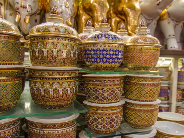 A collection of handcrafted Benjarong ceramics, showcasing intricate patterns and gold embellishments, a traditional Thai porcelain art once reserved for royalty.