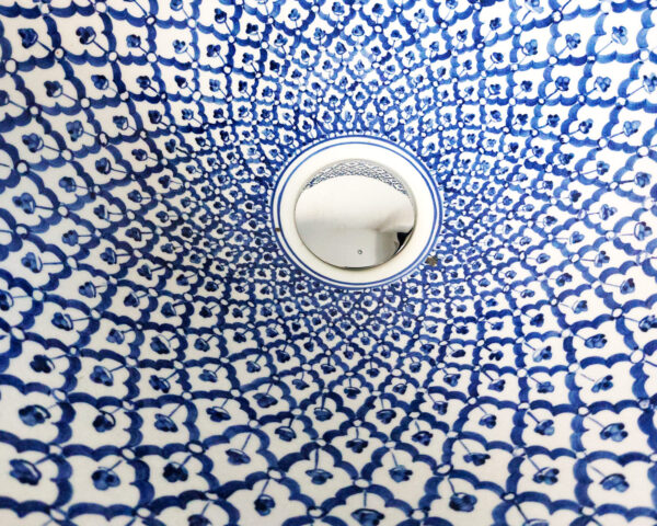 Close-up of the blue mosaic sink, highlighting the precise hand-painted details.