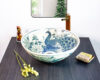 Thai-inspired ceramic sink featuring a majestic blue peacock design, showcasing exquisite craftsmanship.