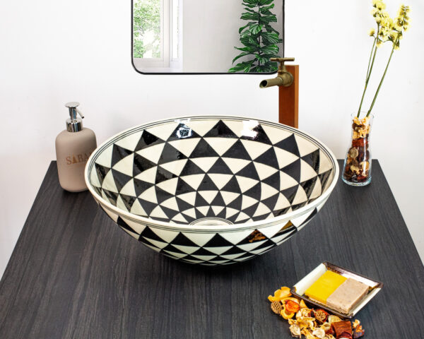 Bold black-and-white geometric ceramic sink with an optical illusion pattern for a modern touch.