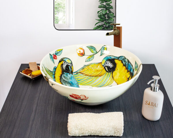 Lush tropical-themed ceramic sink with colorful parrots and foliage, perfect for nature lovers.