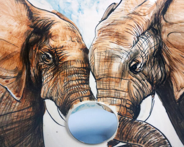 Close-up of hand painted elephant faces and decorative leaves.