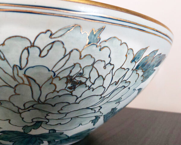 Side angle showing peacock and golden rim on ceramic sink