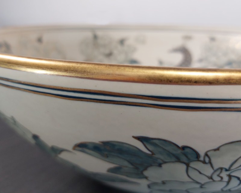 Close-up view of a hand-painted gold rim on a Thai ceramic basin, showcasing the intricate craftsmanship and luxurious finish.