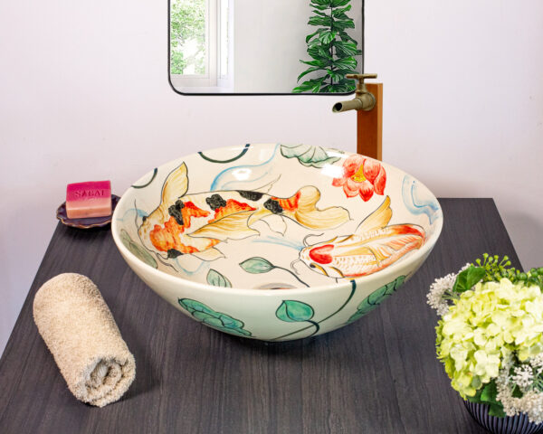 Front view of sink with koi fish swimming among lotus flowers.