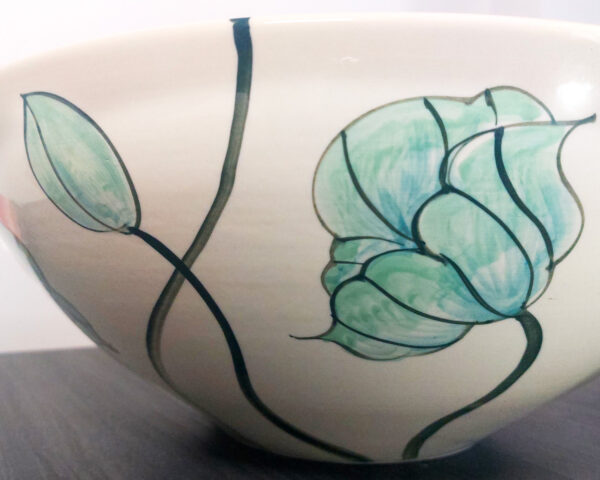 Side view of the bowl showing fish and floral designs.