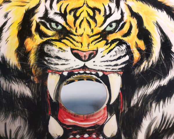 Close-up of tiger face and jungle leaves.