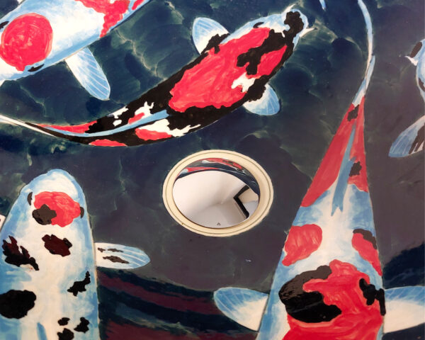 Detail of koi fish inside glossy ceramic sink