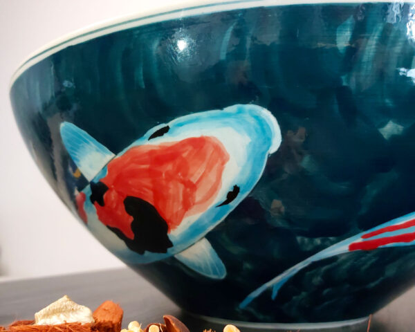 Side profile of koi-themed ceramic wash basin