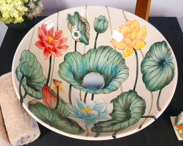 Overhead view of basin with detailed lotus petals and green leaves.