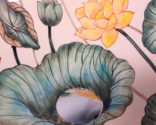 Close-up of hand painted lotus design in red and yellow.