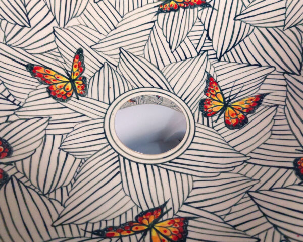 Close-up of butterfly and foliage design on the Monarch Canopy ceramic basin.