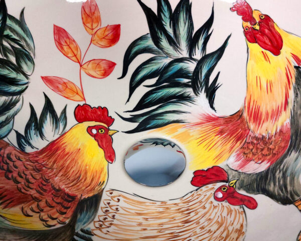 Close-up of painted roosters and garden inside ceramic basin
