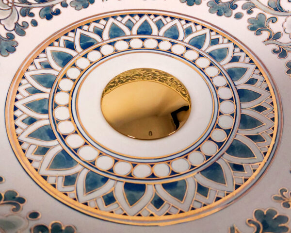 Close-up of floral artwork and gold paint inside ceramic basin
