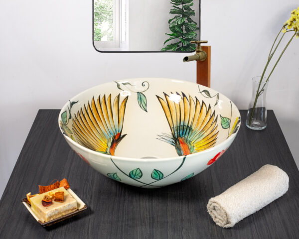 Ceramic sink with vibrant birds in flight from front angle