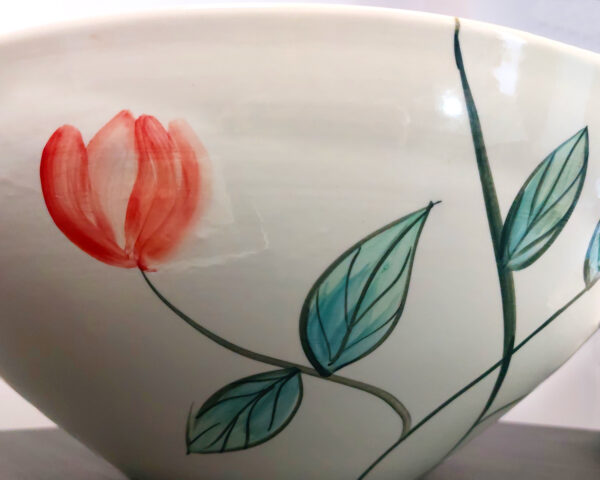 Side view of hand-painted bird design on ceramic bowl