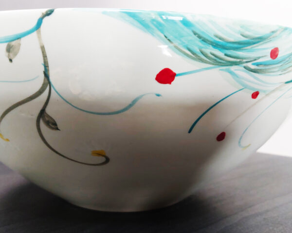 Side profile of Whispering Breeze handmade ceramic basin, showing sculptural form and painted movement.